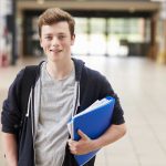 Portrait Of Male Student Standing In College Building