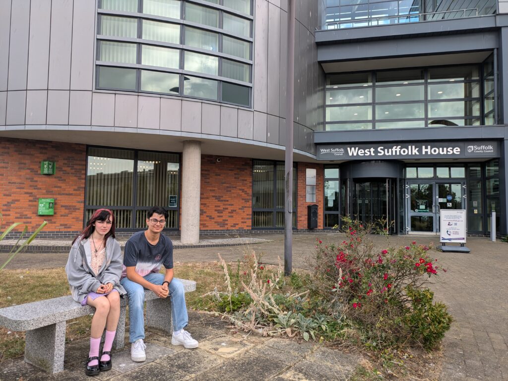 Camille and Mohamad sitting outside West Suffolk House in Bury St Edmunds